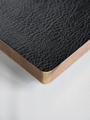 Black, textured B6 notebook featuring a sophisticated grained cover and elegant contrasting gold-toned edges.