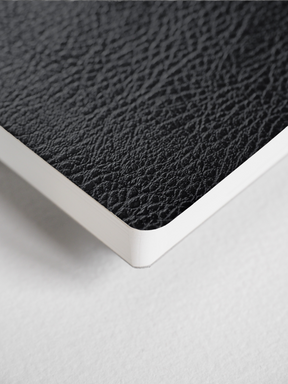 B6 lined notebook featuring a deep, textured charcoal cover and crisp white edges, perfect for writing or journaling.