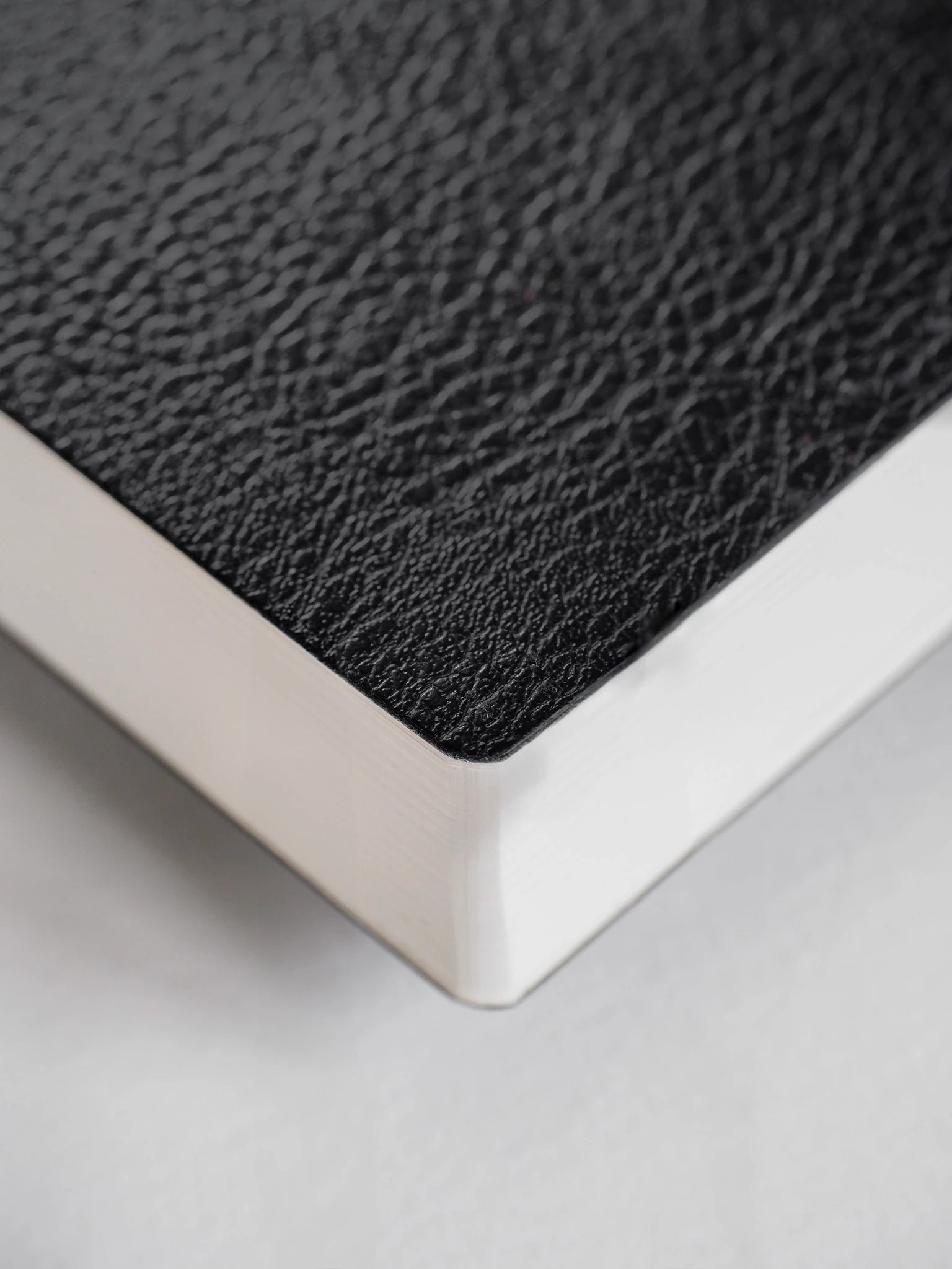 Close-up of a textured black surface with a white border on a light gray background
#Color_Onyx