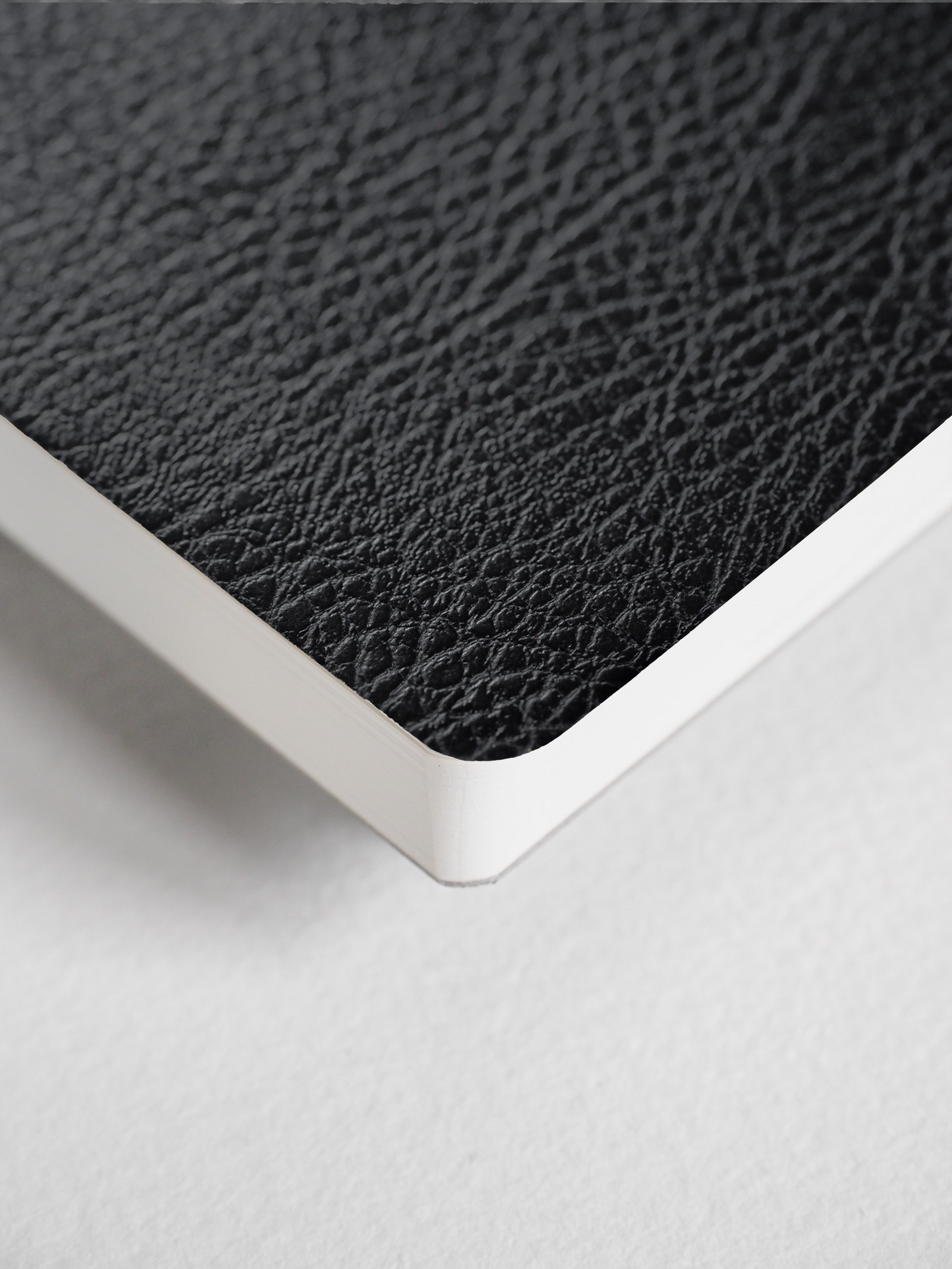 A dark charcoal, textured planner cover featuring a sophisticated faux-leather pebbled grain finish and clean binding detail.