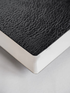 Slim, horizontal planner featuring a deep black, textured faux-leather cover, perfect for comprehensive full-year 2026 organization.
