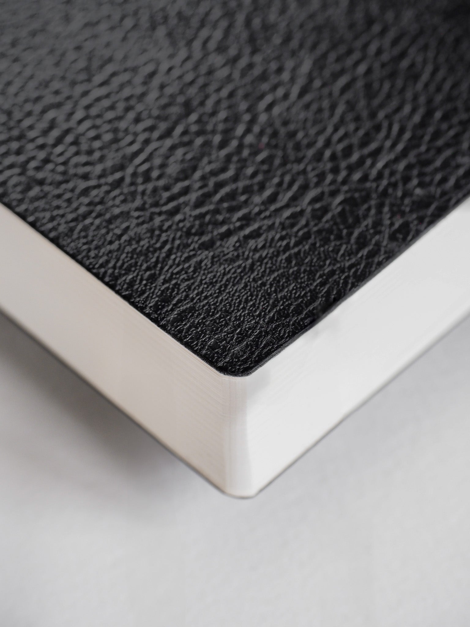Textured dark gray planner notebook with a subtle pebble grain pattern, showcasing its professional appeal and crisp white edges.