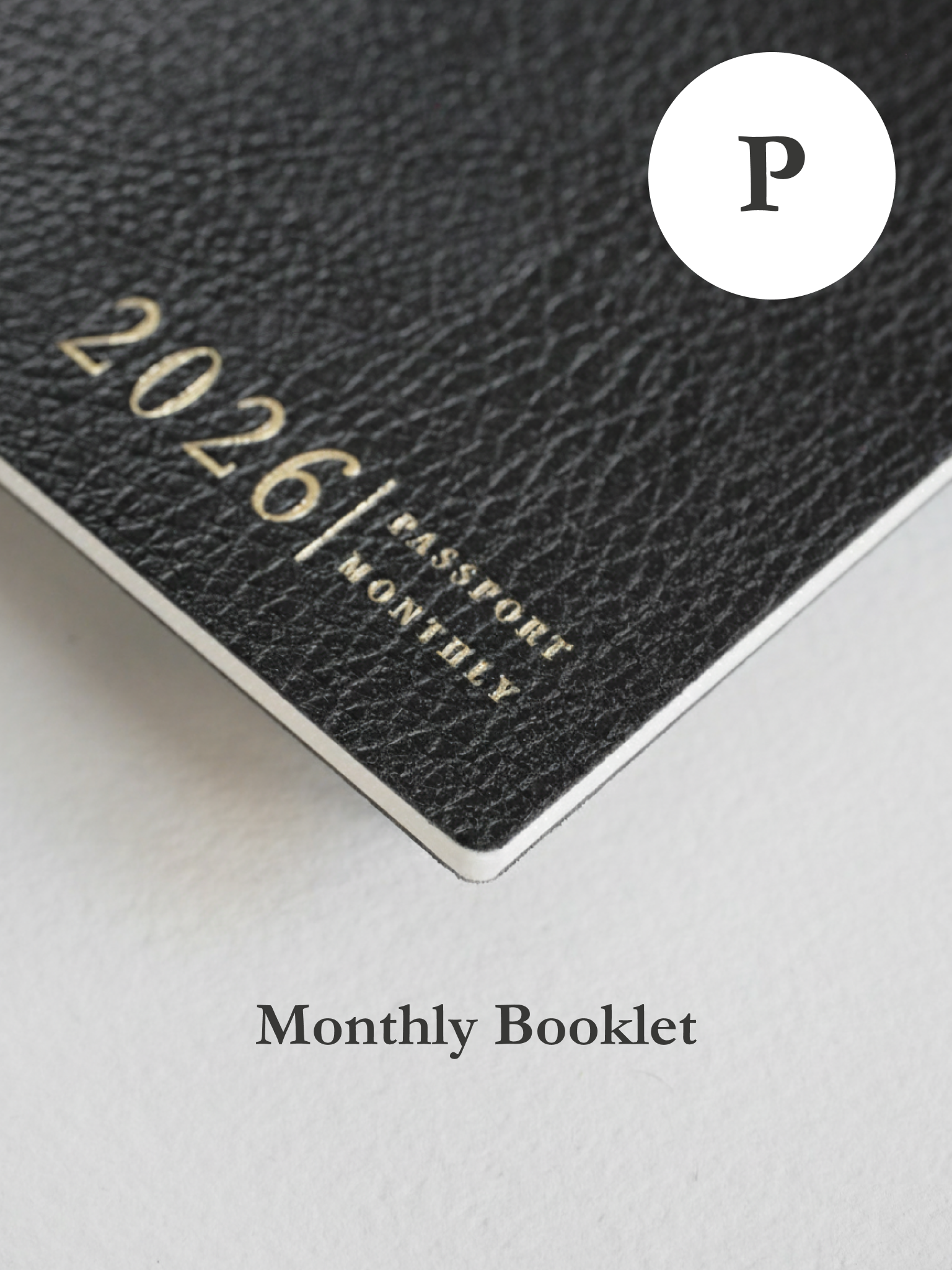 Sleek, textured dark gray booklet featuring elegant metallic gold lettering displaying "2026 Passport Monthly."