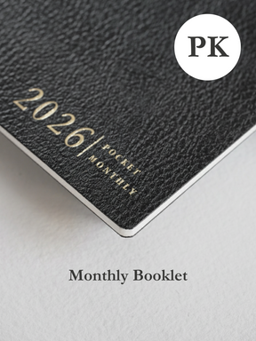 Matte charcoal booklet cover featuring elegant, debossed gold lettering that reads "2026 Pocket Monthly."