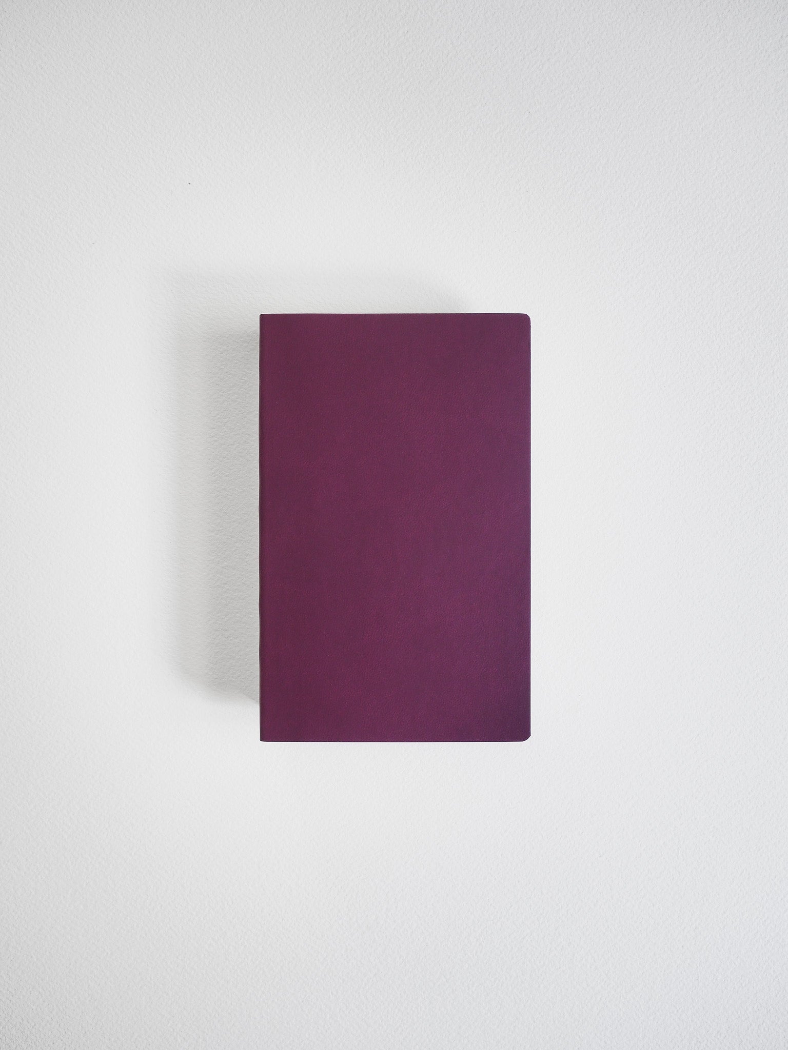 A solid, deeply hued plum notebook with a minimalist cover, ready for journaling or structured note-taking.