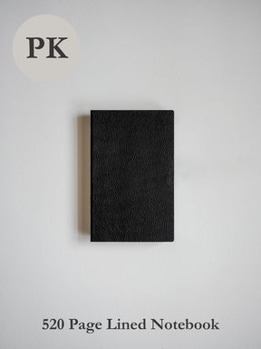Sleek, pocket-sized notebook bound in smooth, textured matte black material, offering a compact journal for writing and daily notes.