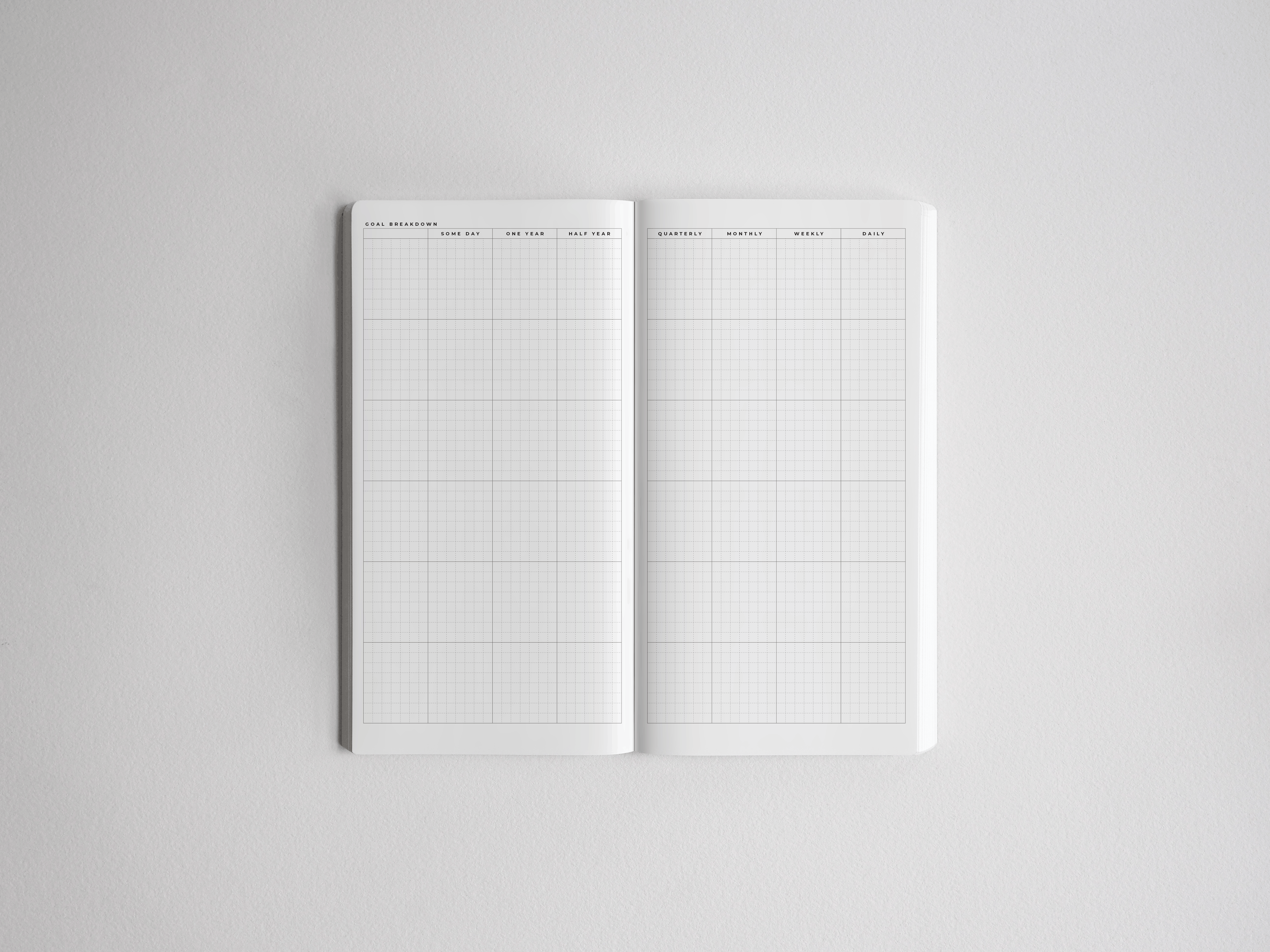Open academic planner featuring a structured white grid layout with labeled sections for goal breakdown, quarterly, and daily planning.