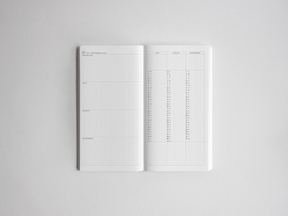 Functional academic planner open to structured, lightly gridded pages, featuring monthly layouts and date slots for organized yearly scheduling.