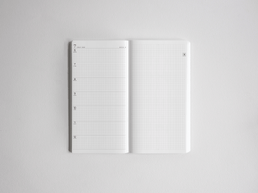 Academic full-year planner open to reveal a structured monthly date layout and complementary squared graph paper for comprehensive academic note-taking.