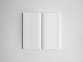 Open academic planner displaying two pages of crisp white graph paper grid lines, ideal for detailed note-taking and year planning.