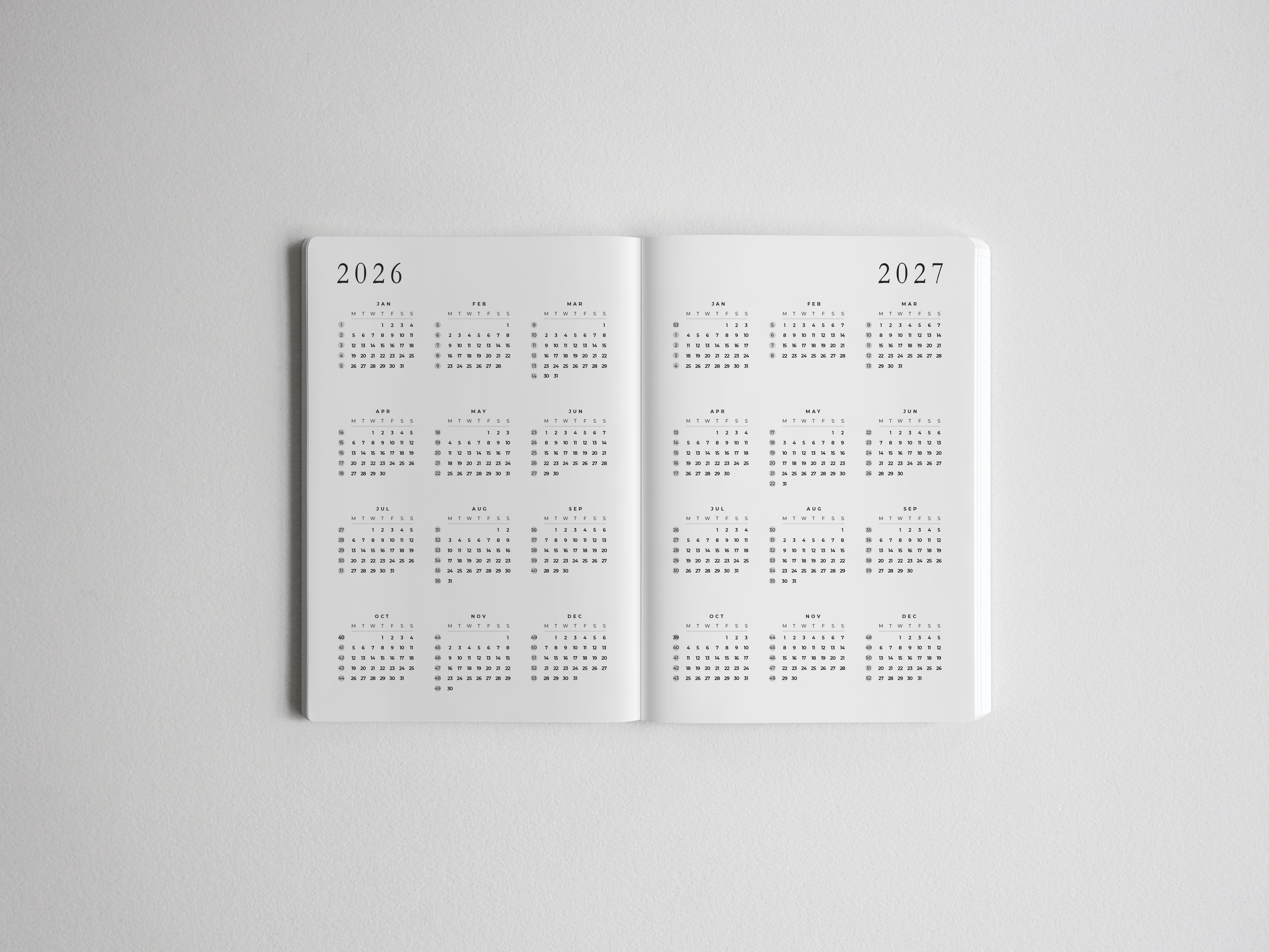 Open B6 academic planner displaying two pages of comprehensive full-year vertical grid calendars for scheduling across 2026 and 2027.