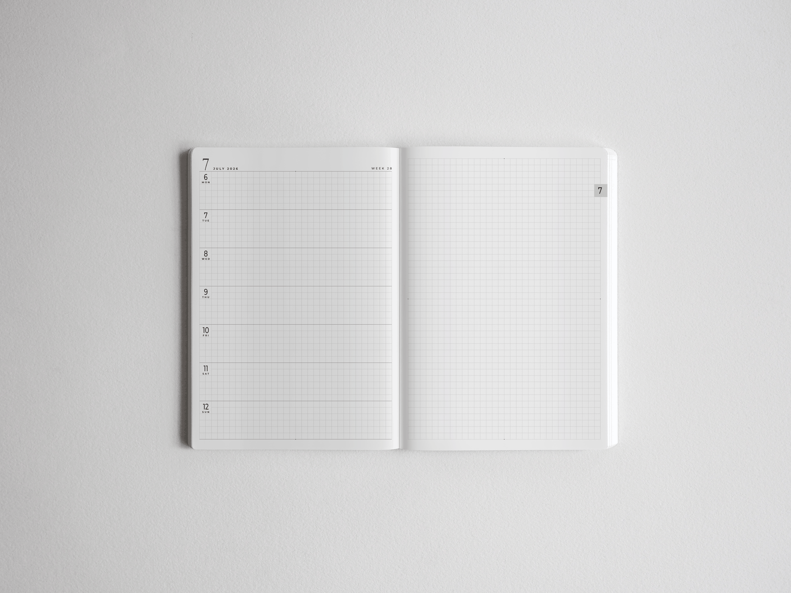 Open white academic planner showcasing organized study space, featuring lined sections for scheduling and structured grid graph paper for detailed note-taking.