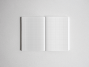 The open academic planner displays two white pages covered in light, pale-gray graph grid lines, suitable for versatile year-long note-taking and planning.