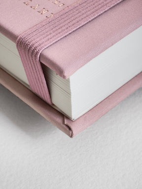 Soft blush pink B6 vertical planner for 2026, featuring an elegant fabric-wrapped spine and subtle embossed detailing across the cover.