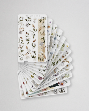 A seasonal set of botanical washi strip stickers featuring delicate, muted illustrations of pressed flowers, leaves, and natural greenery.