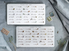 Elegant set of nine small, square stickers featuring repeating black ink floral and stylized script motifs, designed for planning or calendar embellishment.