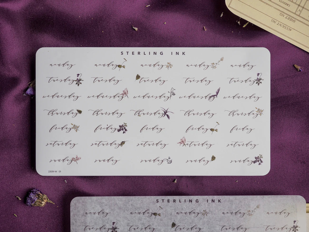 Decorative planner sticker set featuring the seven days of the week, each labeled and adorned with delicate coordinating floral and star motifs for journal planning.