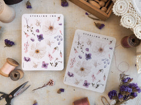 Three pale, watercolor floral sticker sheets featuring delicate botanical patterns of pink, purple, and cream blossoms, suitable for journaling.
