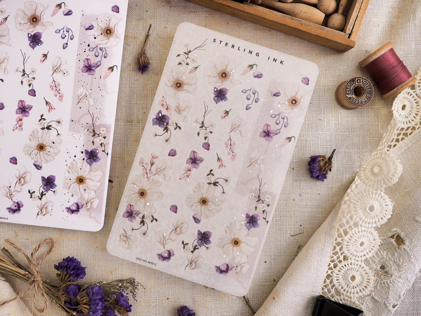Delicate washi sticker sheet featuring a watercolor pattern of tiny purple, dusty blue, and pink wildflowers under the text "STERLING INK."