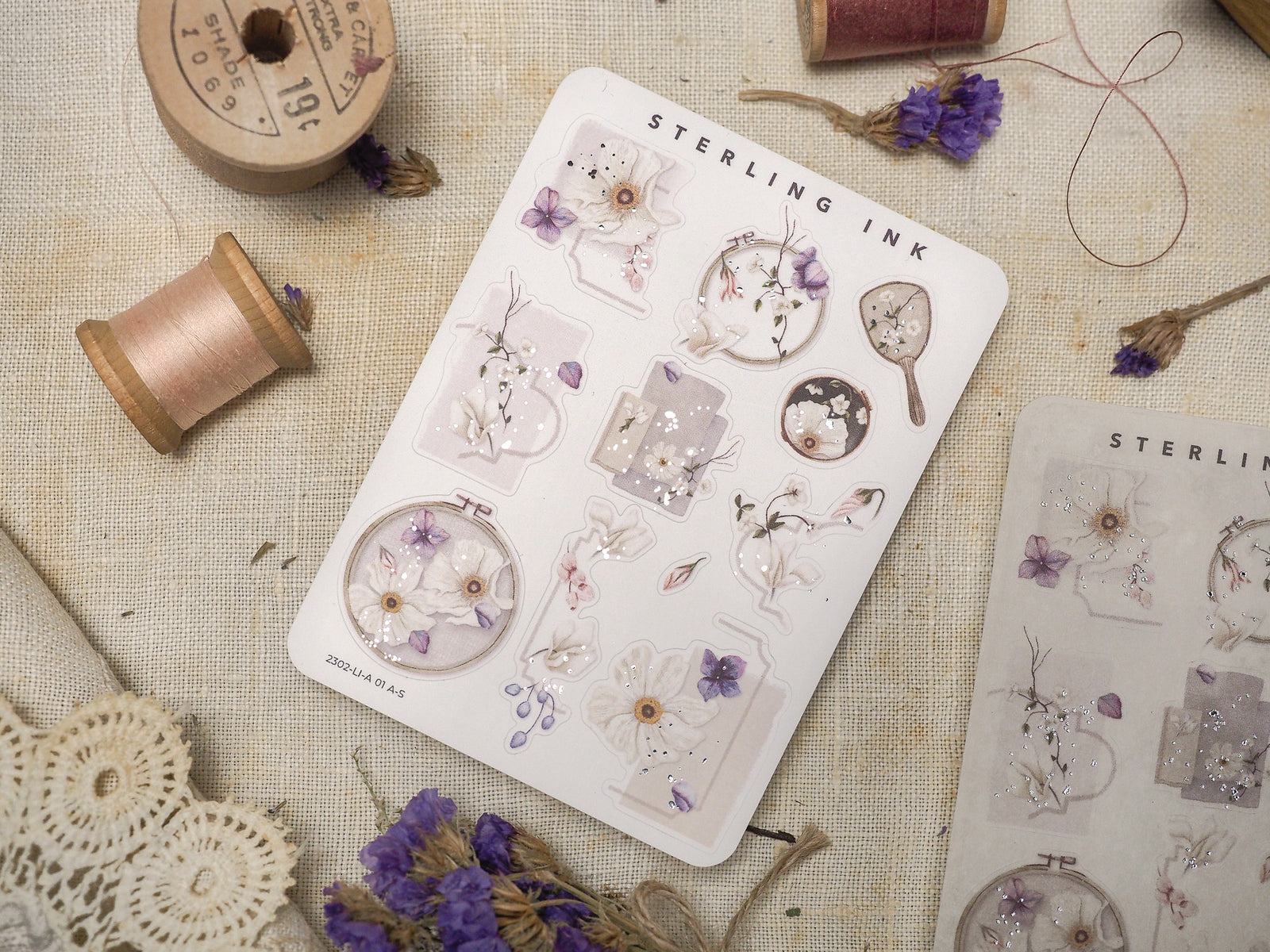Watercolor floral icon sticker sheet featuring delicate pastel botanicals, pink and purple blooms, and elegant silver foil accents for crafting.