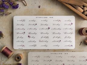 Decorative sticker sheet for February 2023, featuring handwritten weekdays, calendar dates, and elegant floral accents for journal planning.