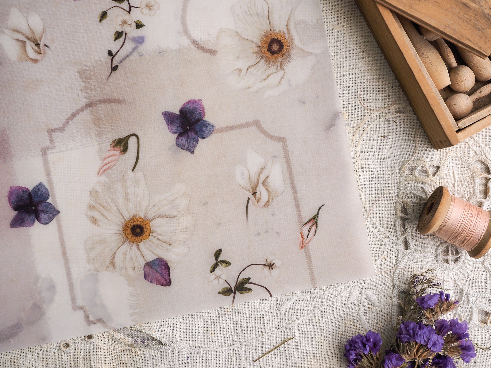 Botanical-themed planner page with creamy beige vellum, featuring watercolor illustrations of white daisies, purple flowers, and delicate green botanicals within subtle framed borders.