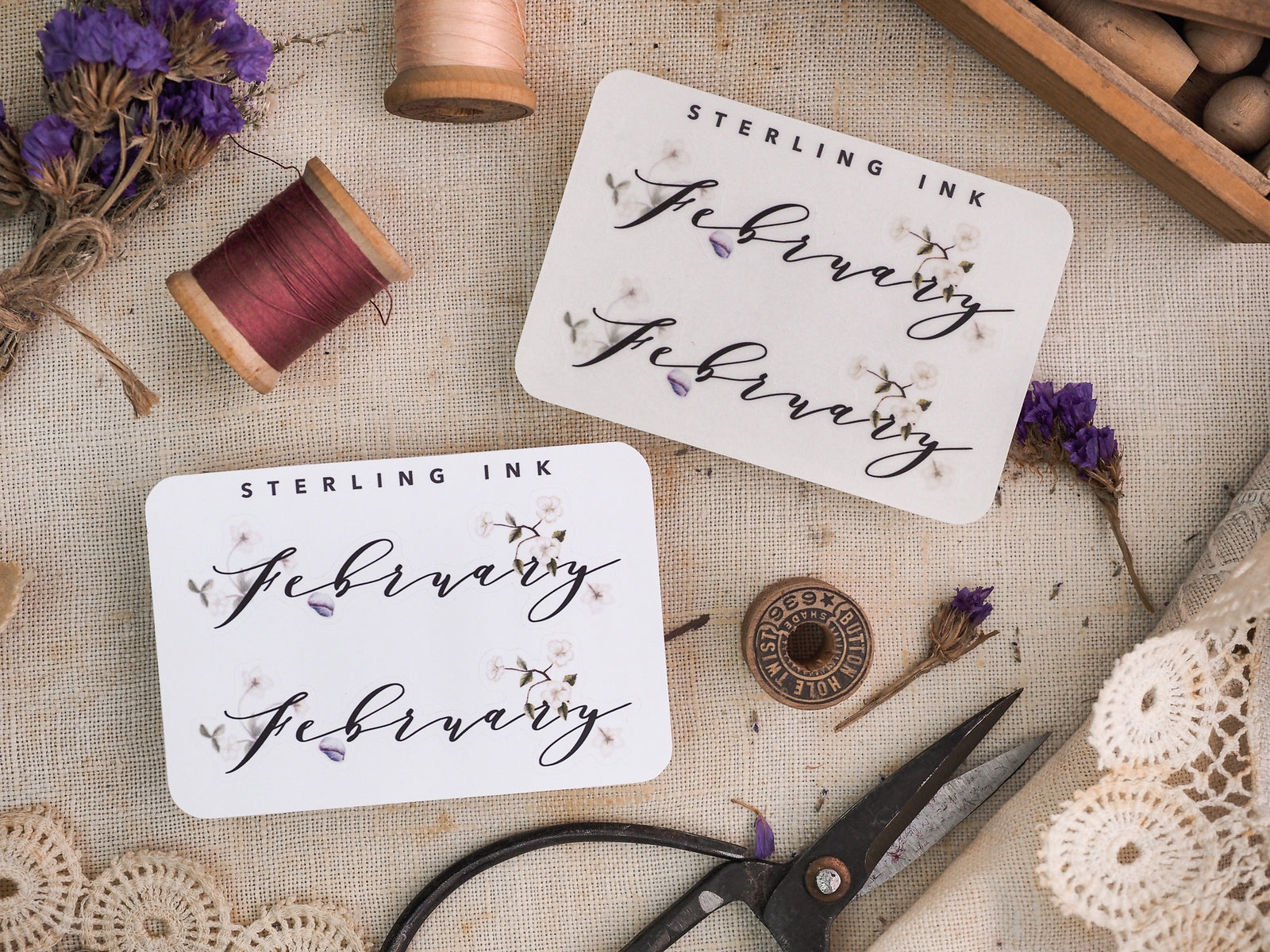 White monthly planner sticker for February featuring "Sterling Ink" in elegant script and subtle decorative floral elements for journaling.