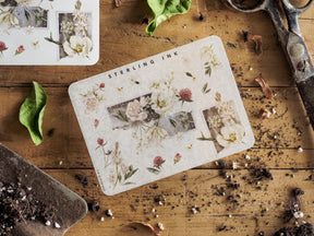 A sticker sheet with corner accents, adorned with vintage botanical illustrations of delicate pressed flowers and earthy green foliage.