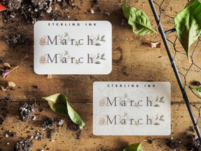 Minimalist "March" month sticker set featuring the word on creamy white card stock and accented with delicate green watercolor leaf drawings.