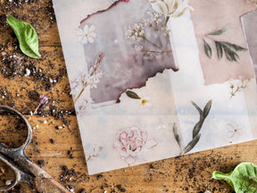Decorative vellum featuring a soft botanical collage of pale pink blossoms, creamy watercolor flowers, and delicate sage green foliage.