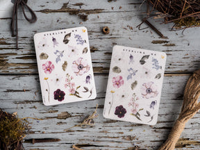Delicate botanical sticker set featuring watercolor elements of soft pink, purple, and cream blossoms, surrounded by detailed foliage.