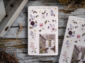 Decorative sticker sheet featuring an arrangement of watercolor floral illustrations and a central scenic watercolor image of an elegant conservatory.