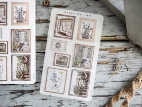Vintage picture frame stickers in sepia tones, featuring decorative collages of rustic interiors, antique furniture, and botanical elements for crafting.