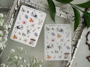 Mini sticker sheet featuring delicate watercolor icons of vintage bicycles, lush floral bouquets, and various natural botanical elements.