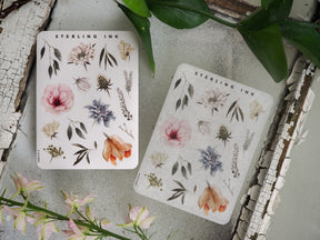 Delicate botanical sticker sheets featuring soft pastel watercolor elements, including peonies, lush leaves, and assorted natural floral illustrations.