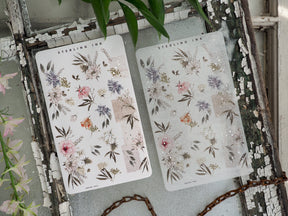 Two sheets of pastel botanical washi stickers featuring delicate watercolor clusters of pink, lavender, and mauve flowers and leaves.