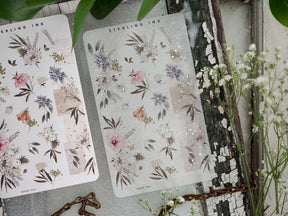 Delicate sheet of washi sticker strips featuring a soft pastel watercolor botanical pattern with clustered pink, purple, and muted greenery florals.