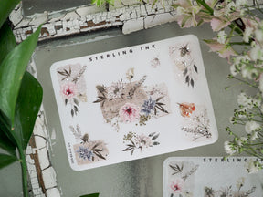 Intricate sticker sheet adorned with delicate, romantic floral clusters, dried botanical elements, and shimmering silver foil accents.