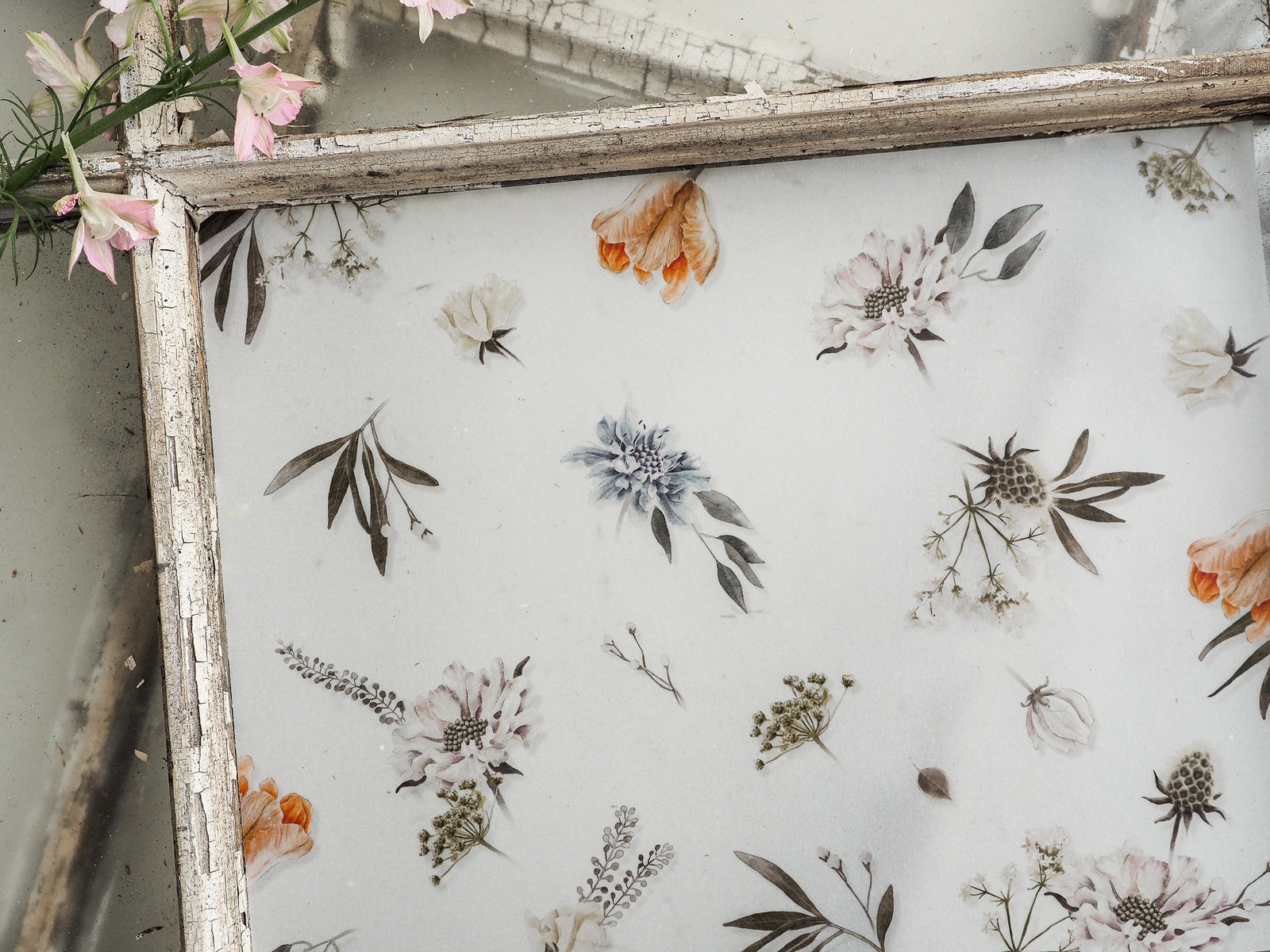 Delicate vellum sheet featuring a scattered botanical pattern of pale peonies, grasses, and diverse leaves for May 2023 journaling.