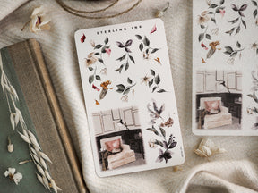 Watercolor sticker sheet displaying delicate winter botanicals, including leafy green arrangements and small seasonal accents for journaling or planners.