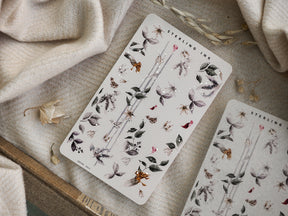 Botanical washi strip sticker sheet with muted, earthy tones and delicate depictions of leaves, small flowers, and subtle glittering accents.