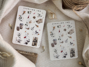 Decorative icon sticker sheets featuring seasonal metallic illustrations, including silver foil accents on detailed drawings of leaves, small pots, and festive elements.