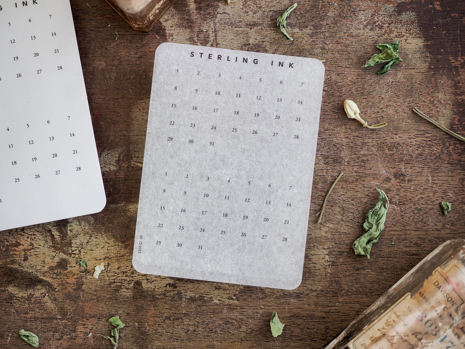 Calendar date stickers printed on pale gray cardstock, featuring a clean grid design and numbers 1 through 31 for seasonal planning.