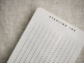 Structured white grid strips for planning and tracking, featuring a numbered format and a decorative "STERLING INK" title compatible with various planners.