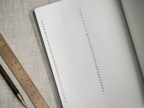 Open planner pages showcasing a clean, light gray gridded design perfect for customizable tracking, planning, and organized note-taking layouts.