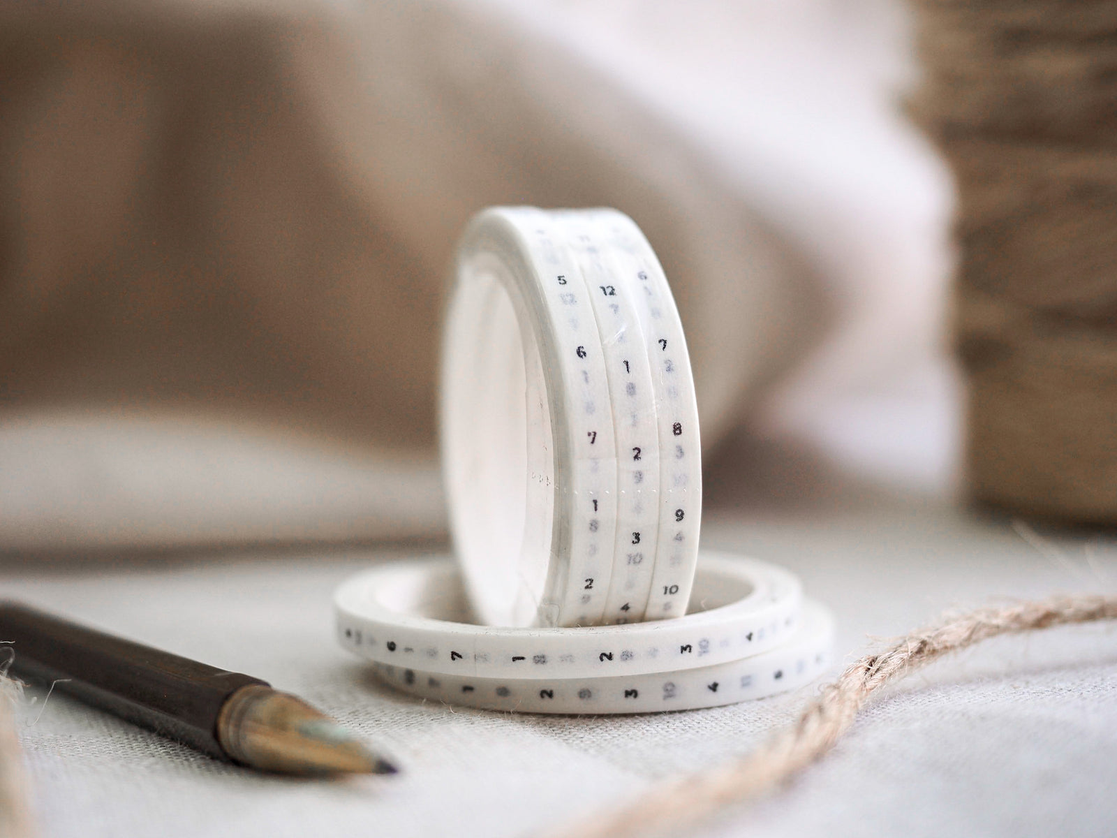 White hourly washi tape with black numerals printed in a time line pattern, ideal for organizing daily planners and journals.