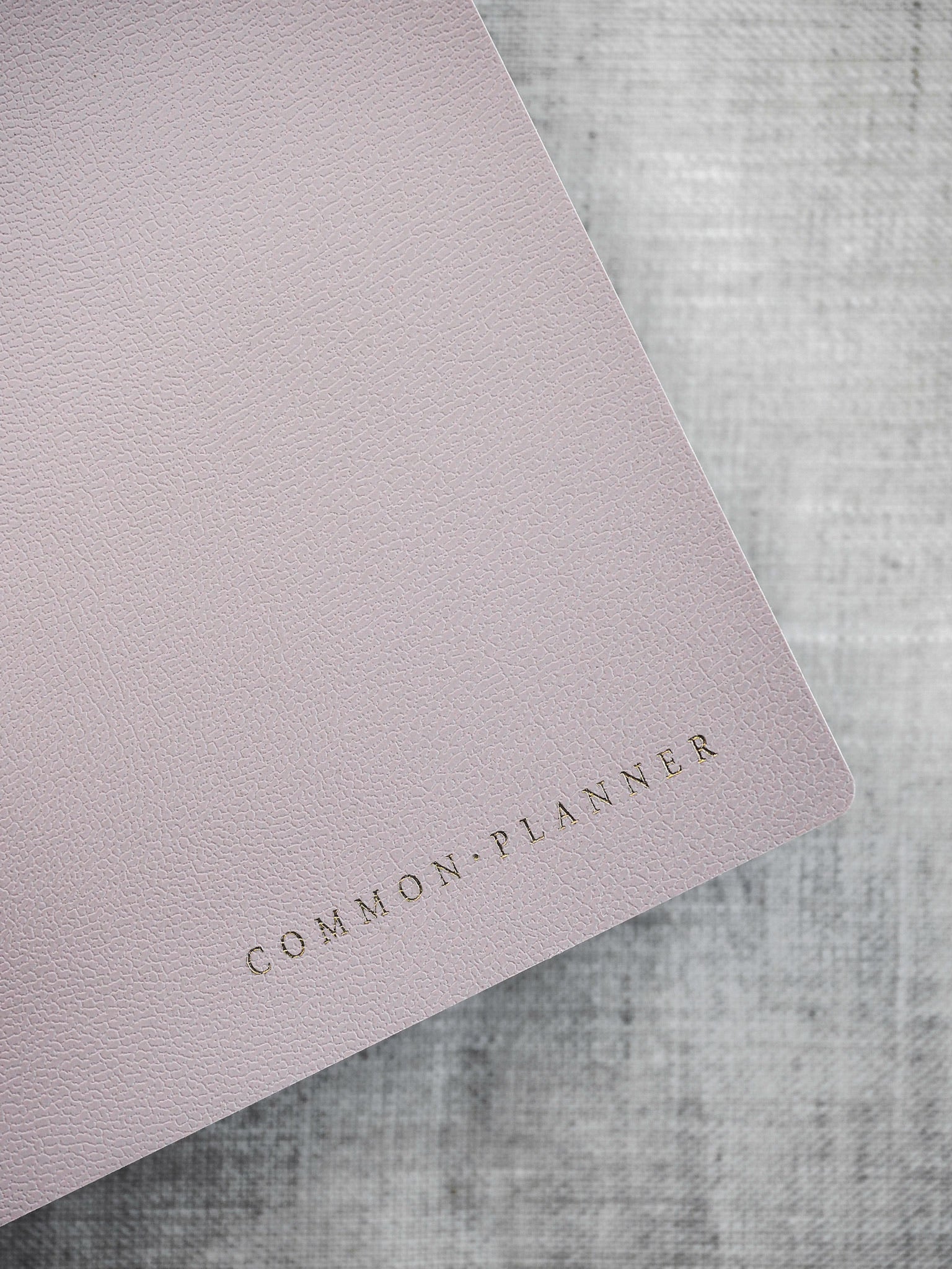 Minimalist blush pink planner cover featuring the text "COMMON PLANNER" in elegant, foiled lettering.