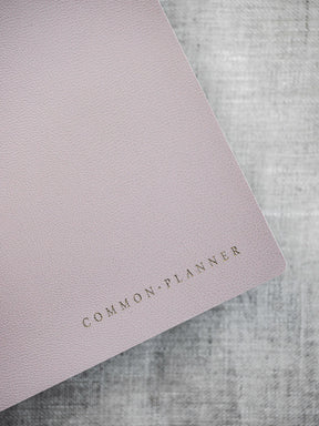 Minimalist blush pink planner cover featuring the text "COMMON PLANNER" in elegant, foiled lettering.