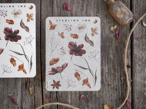 Botanical sticker set featuring detailed autumn illustrations of deep burgundy flowers, brown foliage, and delicate white wildflower elements.